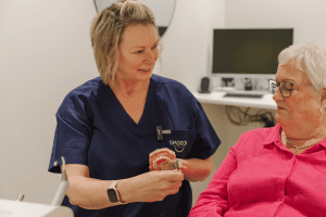 An elderly couple laugh, knowing their dentures are fresh & clean after a deep machine clean at the Dental hygienists in Chch