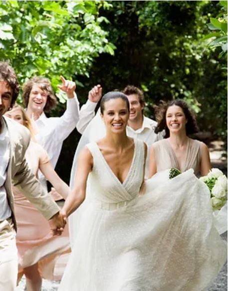 Bride smiling and running with her Groom